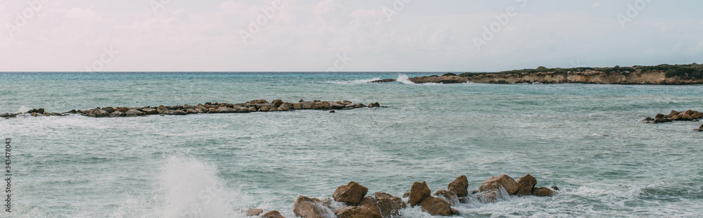 panoramic shot of rocks near mediterranean sea against sky