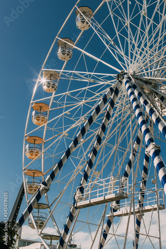 low angle view of metallic ferris wheel against blue sky