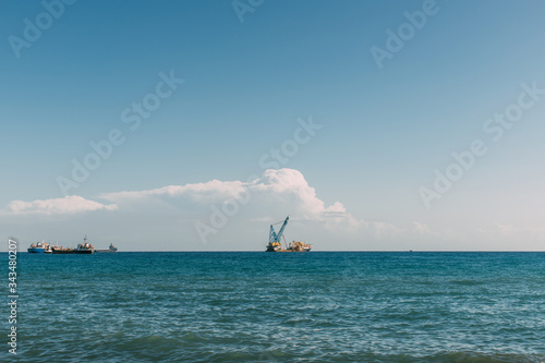 ships in blue mediterranean sea against blue sky with clouds