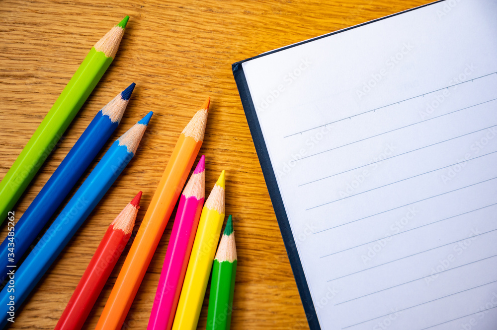 Education background concept. Color pencil on the wooden table with note book. Education background concept. Color pencil on the wooden table with note book.
