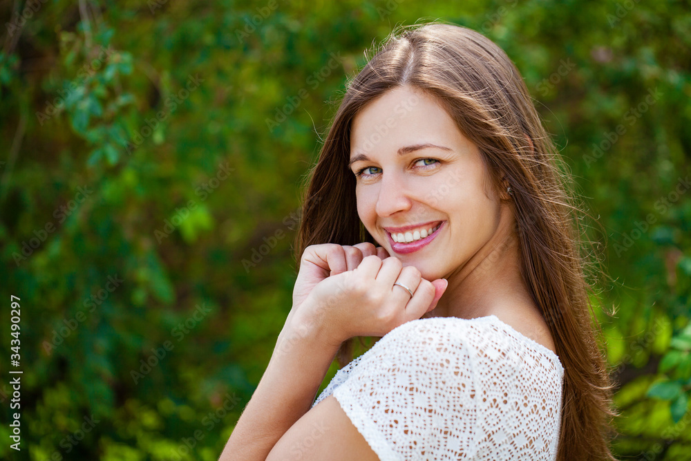 Close up portrait of beautiful young happy brunette woman with fresh and clean skin, summer street outdoors