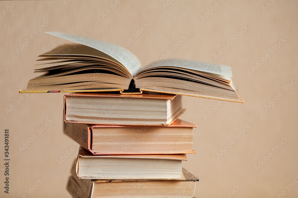 Fototapeta premium a stack of books on the table and one book is opened