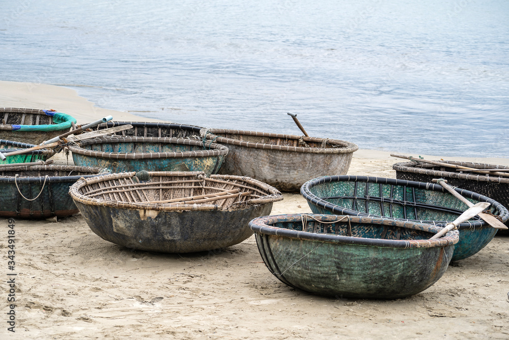 A traditional Vietnamese boat placed on a beach located in My Khe Beach, Danang, Vietnam. This round basket boat is made of woven bamboo. It is also called Thung Chai.