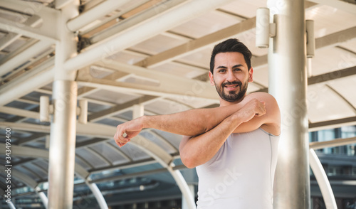 Young man runner stretching for warming up before running or working out