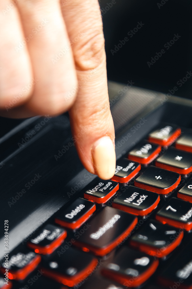A woman's hand presses a key: home, on the computer. The girl encourages you to stay at home through a metaphor. A woman's hand presses a key: home, on the computer. The girl encourages you to stay at home through a metaphor.
