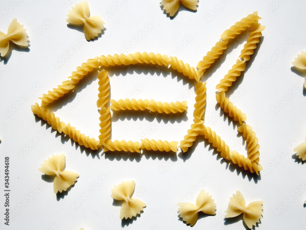 Pasta in the shape of a fish, pasta folded in the shape of a fish, pasta on the table is folded in a pattern. Pasta in the shape of a fish, pasta folded in the shape of a fish, pasta on the table is folded in a pattern.