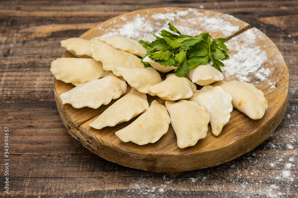 Frozen dumplings on a wooden plate on a wooden background Frozen dumplings on a wooden plate on a wooden background