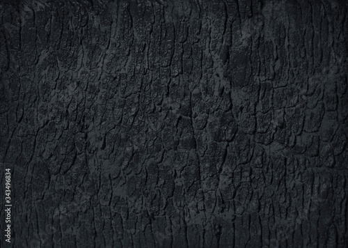 Natural cracked black activated charcoal texture for backgrounds. Top view.