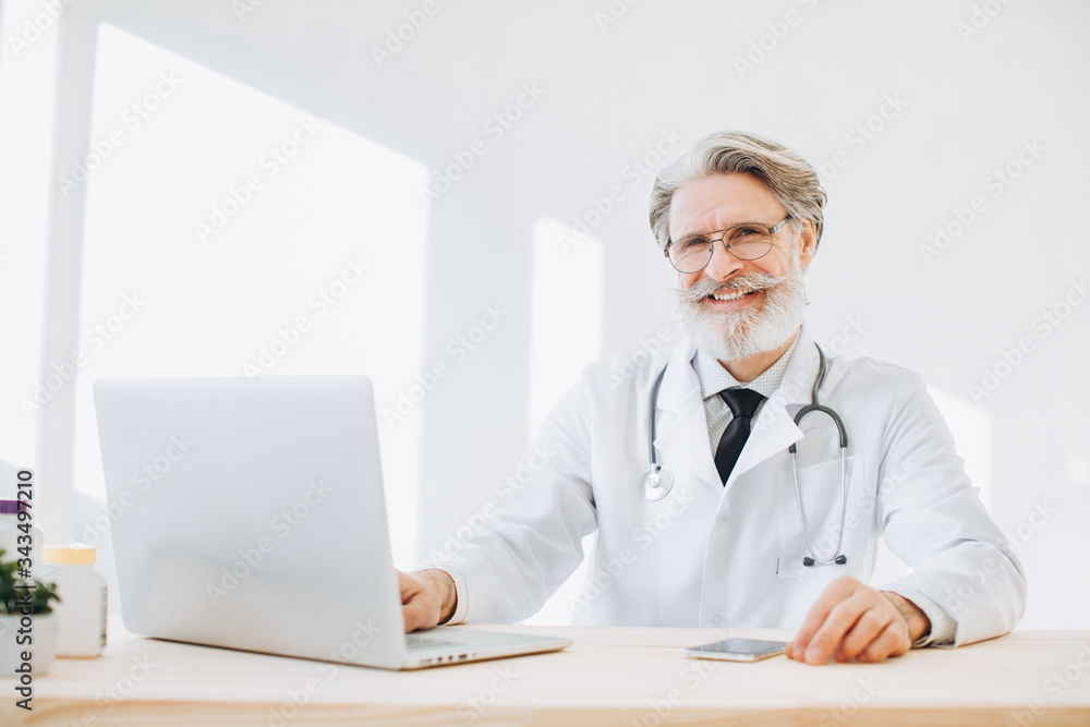 Portrait of senior doctor sitting in medical office Portrait of senior doctor sitting in medical office