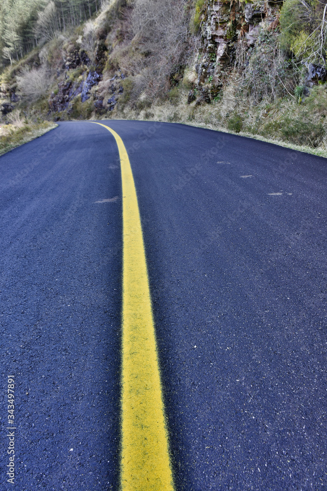 Obraz premium old road crossed by yellow line