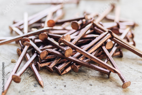 Fototapeta Naklejka Na Ścianę i Meble -  Shiny copper nails scattered on a wooden floor