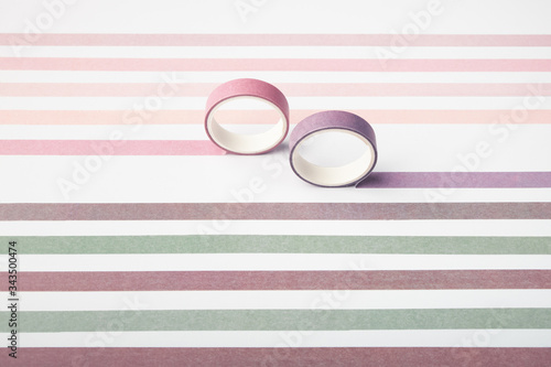 Two adhesive tape rolls and parallel strips on white background photo