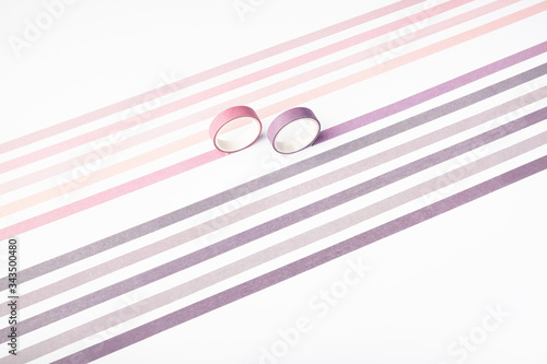 Two adhesive tape rolls and parallel strips on white background photo