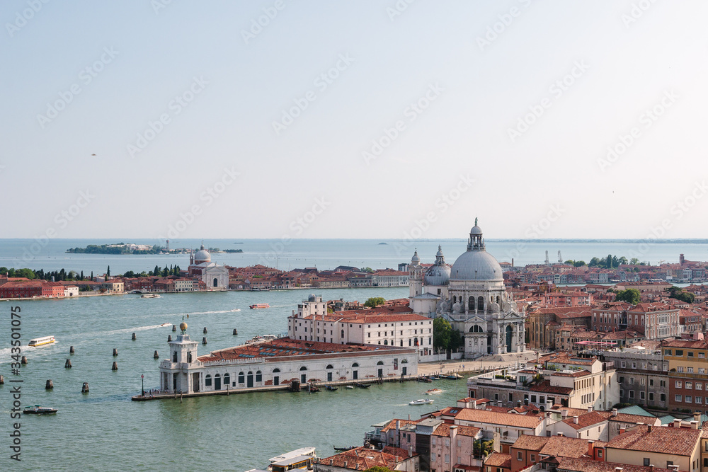  Venice canal in summer time. Italian view. Roof, sea, boat in sunny day. Old city.  Popular tourist destination of Italy. Europe. Top view from Saint mark's tower. Basilica Santa Maria della Salute.