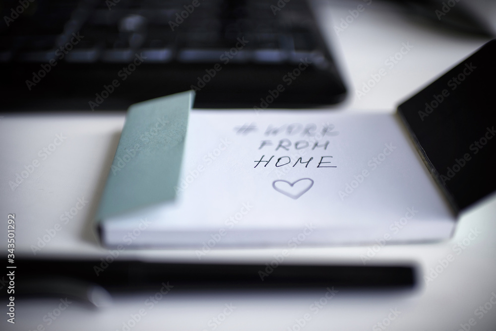 inscription work from home in a notebook on a white background with a keyboard and pen in connection with the coronavirus inscription work from home in a notebook on a white background with a keyboard and pen in connection with the coronavirus