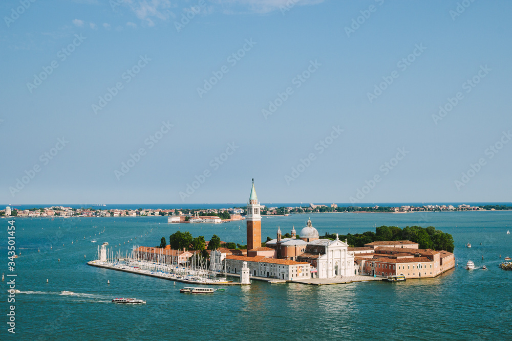 Venice in summer time. Italian view. Roof, sea, boats in sunny day. Old city.  Popular tourist destination of Italy. Europe. Top view from Saint mark's tower. Cathedral of San Giorgio Maggiore. Isle.