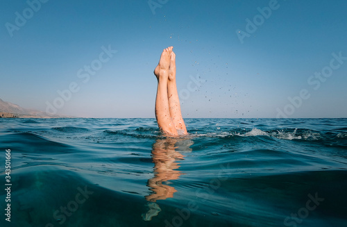 The legs of a freediver girl in the sea. photo