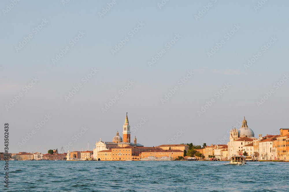  Venice canal in summer time. Italian view. Roof, sea, boat in sunny day. Old city.  Popular tourist destination of Italy. Europe. Basilica Santa Maria della Salute. Church of St. Mary the Triumphant
