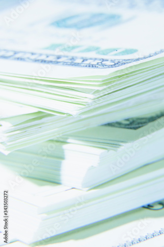 Close up of stacks of hundred US Dollar bills. Shot with shallow depth of field. Selective focus. Vertical image.