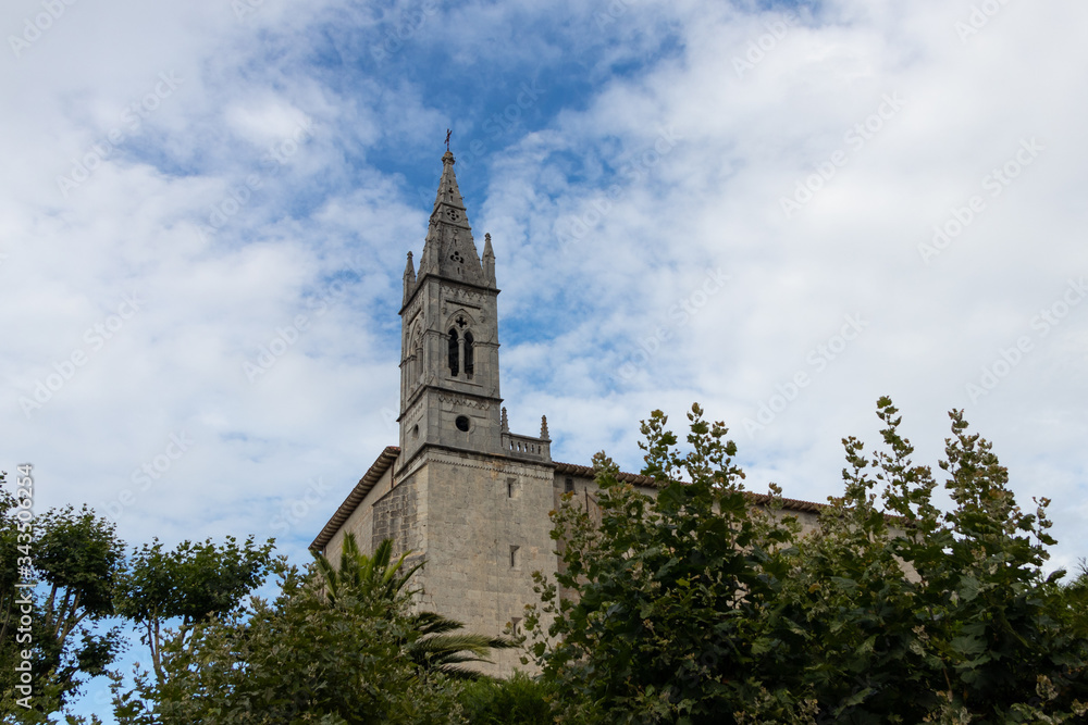 campanario de una iglesia con nubes alrededor y arboles