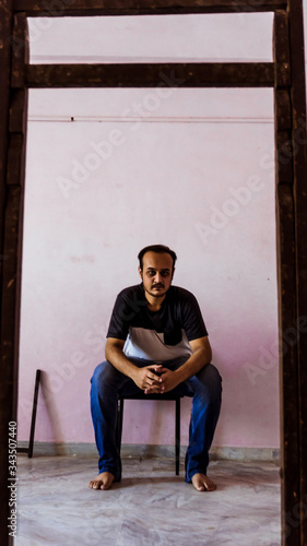 Young man doing timepass alone in the room beacuse for lockdown. photo