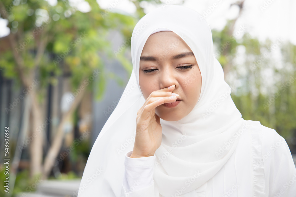 sick muslim woman having runny nose; concept of virus outbreak, biohazard, biological hazard, preventive health care, disease quarantine, coronavirus outbreak control, sickness containment, COVID-19 sick muslim woman having runny nose; concept of virus outbreak, biohazard, biological hazard, preventive health care, disease quarantine, coronavirus outbreak control, sickness containment, COVID-19