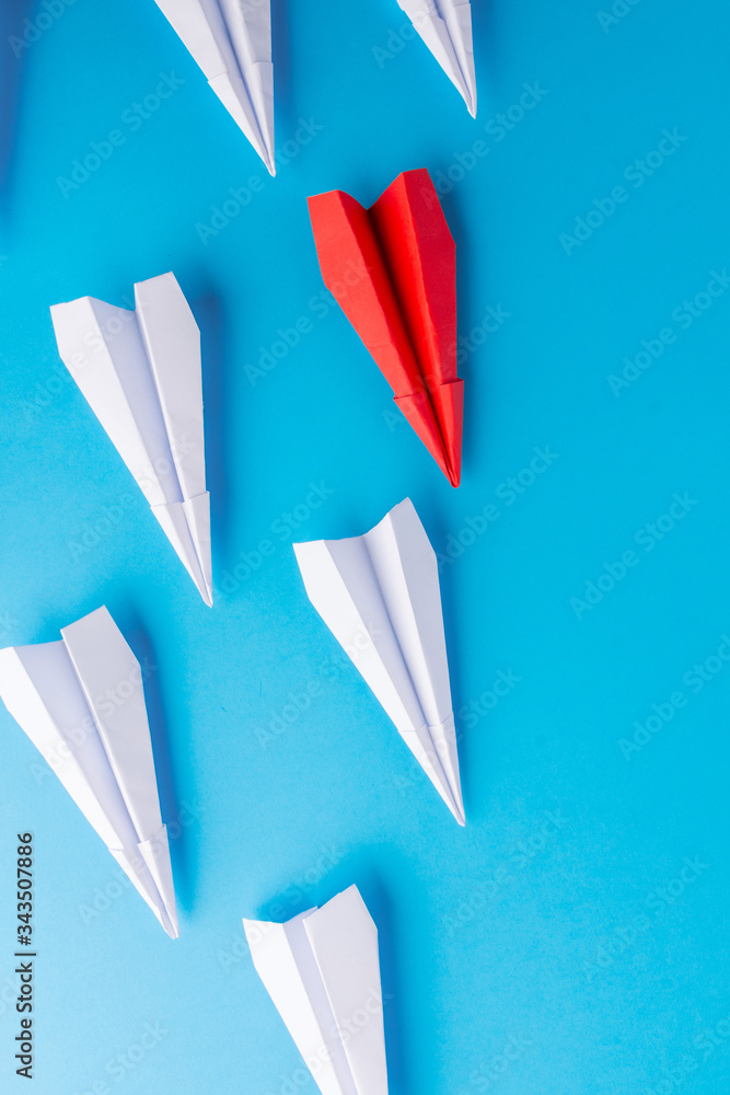 A red plane between small planes. A prominent unit. Blue background A red plane between small planes. A prominent unit. Blue background