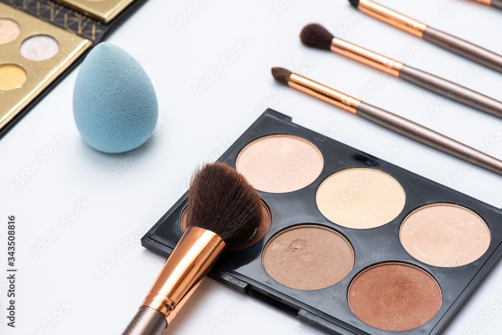 Kit de maquillaje que incluye aplicadores o brochas, bases y paletas de sombras sobre fondo blanco Kit de maquillaje que incluye aplicadores o brochas, bases y paletas de sombras sobre fondo blanco