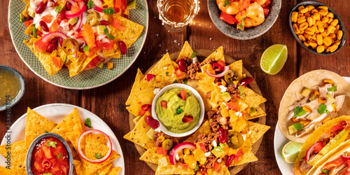 Mexican food panorama, shot from above on a rustic wooden background. Nachos, guacamole, tequila, tacos, a flat lay