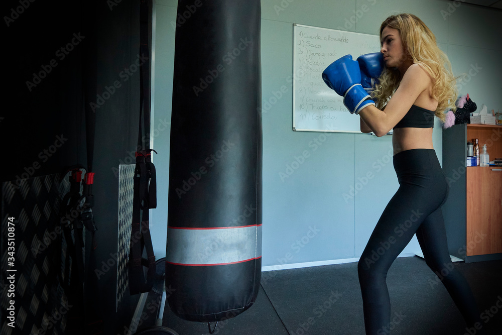 Side view of confident female boxer exercising in gym