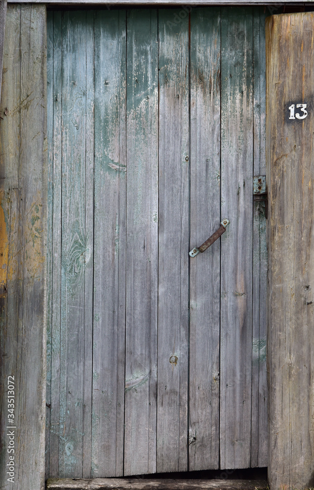 Brown wooden door to the staircase. Old peeling paint Brown wooden door to the staircase. Old peeling paint