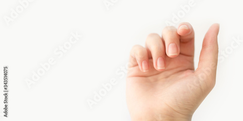 Close up woman hand with nails form of soft square holds something in fingers. Female keeps virtual object. Nail care at home. Copy space.