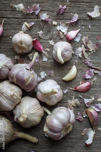The process of cleaning garlic. Garlic and leaves on wooden background.