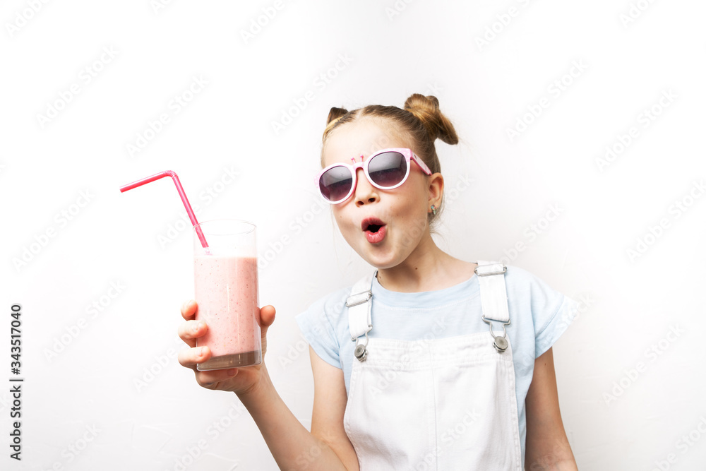 A girl in pink sunglasses drinks a cocktail through a pink straw and exclaims in surprise. A girl in pink sunglasses drinks a cocktail through a pink straw and exclaims in surprise.