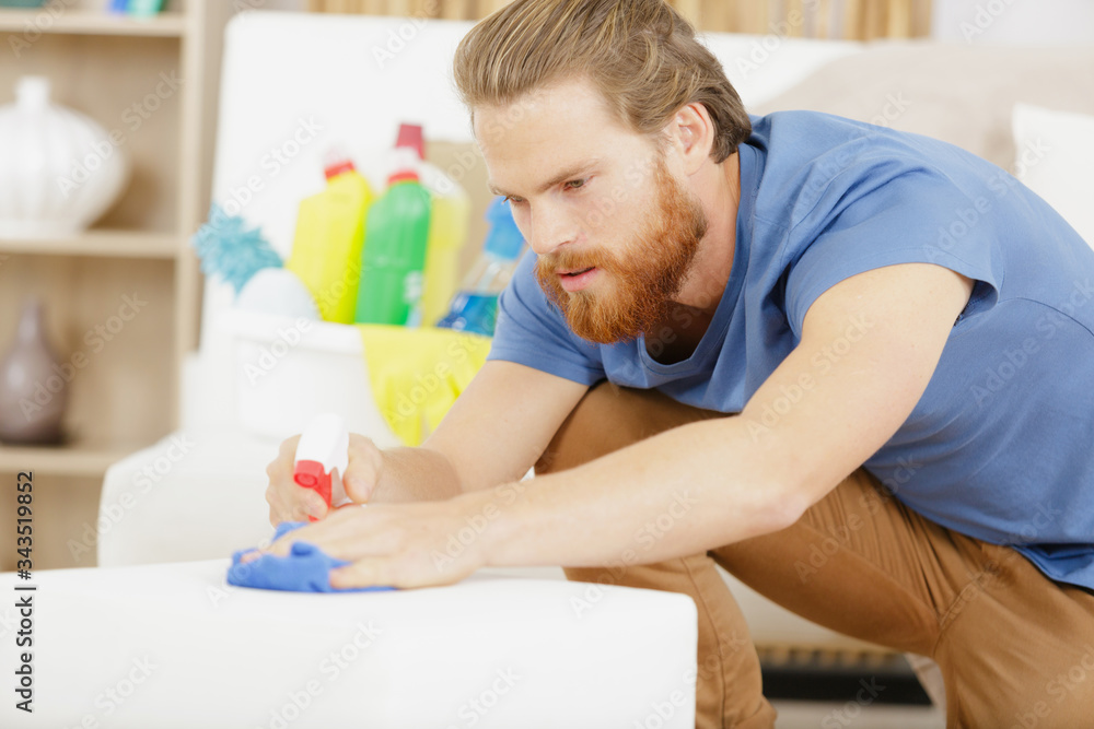 a concentrate man cleaning the sofa a concentrate man cleaning the sofa