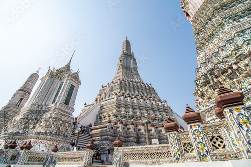 Fotografie Bangkok, Thailand - January, 2020: The Temple of Dawn, Wat Arun, on the Chao Phraya river and a beautiful blue sky in Bangkok, Thailand