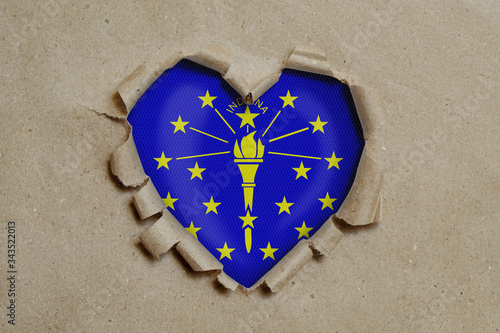 Heart shaped hole torn through paper, showing Indiana flag