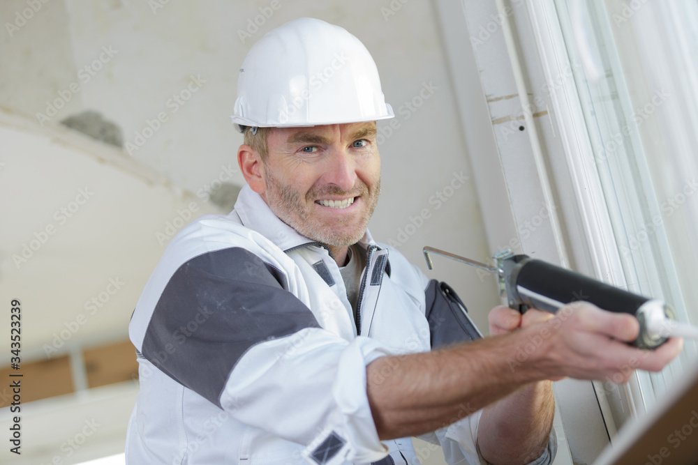 happy builder applying silicone silicone sealant with gun happy builder applying silicone silicone sealant with gun