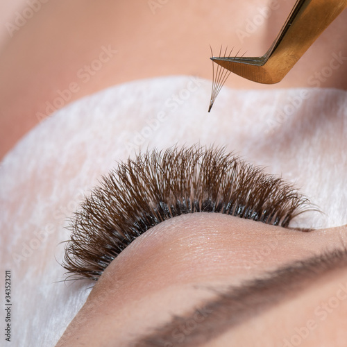 Eyelash Extension Procedure. Woman Eye with Long Eyelashes