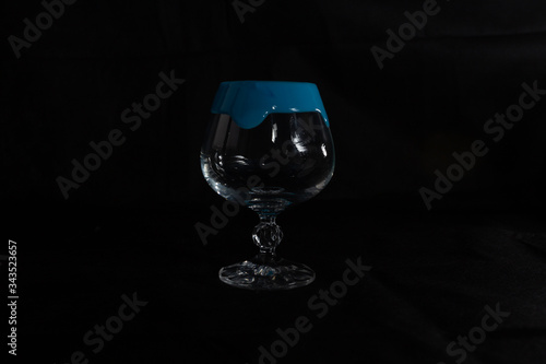 one crystal glass on a dark background with thick gouache