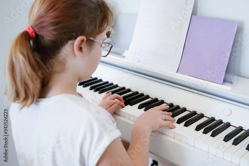 Teenager girl plays the piano.