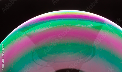 Soap bubble on a black background. Closeup.