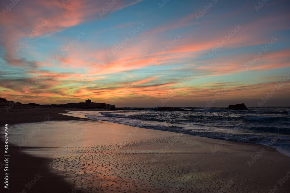 Amazing colorful evening at the beach of Oualidia, Morocco. Shore with reflection of colorful evening sky