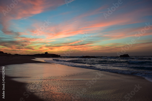 Amazing colorful evening at the beach of Oualidia  Morocco. Shore with reflection of colorful evening sky