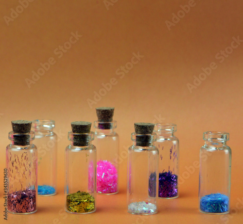 
beautiful small bottles with face glosses stand on a brown background
