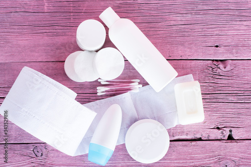 Personal care product on a pink background. Toilet paper, soap, deodorant. The concept of self-care.