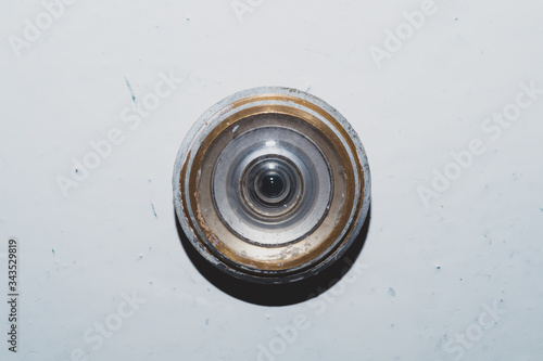 Old peephole on a painted wooden door