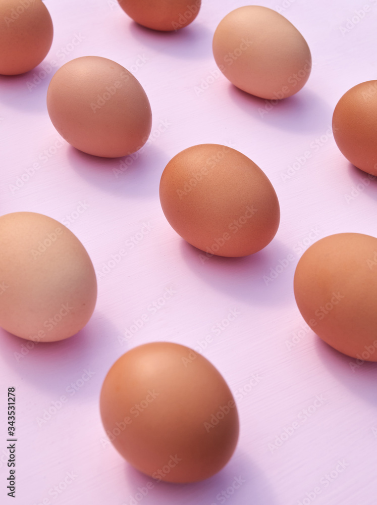 Chicken eggs on a pink background with sunlight and shadows Chicken eggs on a pink background with sunlight and shadows