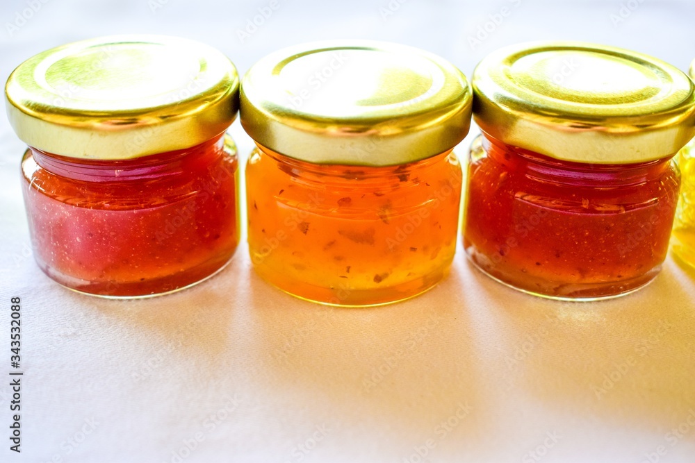 pineapple, orange and strawberry jams in the small glass bottle pineapple, orange and strawberry jams in the small glass bottle