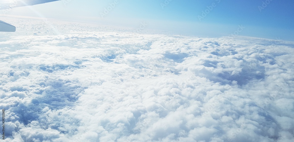 Beautiful view from the plain window flying high above the clouds. Blue Sky and bright sunrays. Beautiful view from the plain window flying high above the clouds. Blue Sky and bright sunrays.